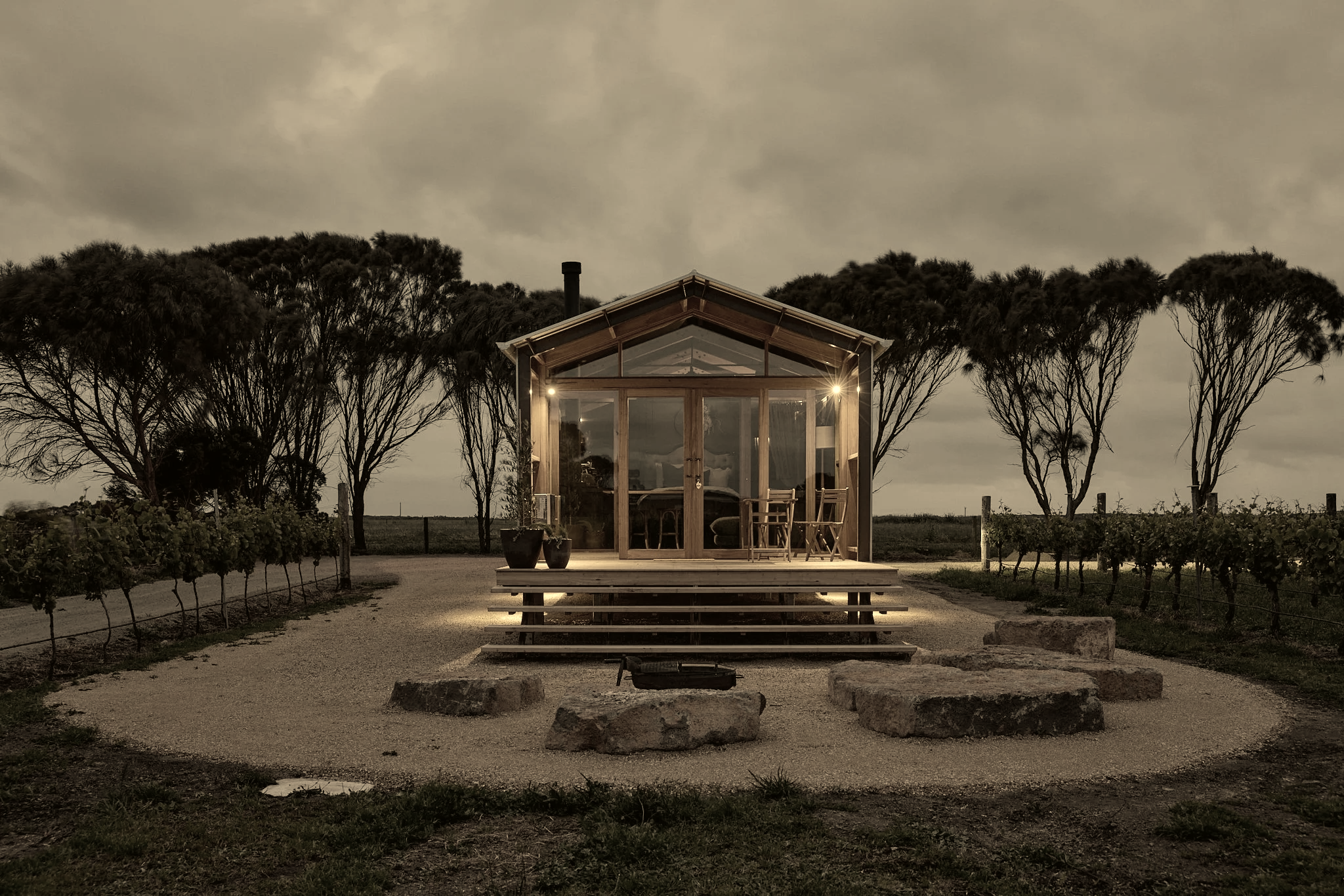 Ample Co. Weekender cabin lit at dusk with fire pit and stone seating